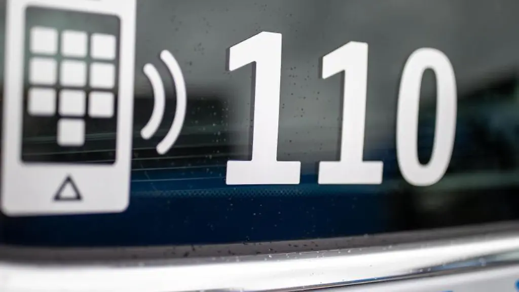 Die-Nummer-des-Polizeinotrufs-110-steht-auf-der-Scheibe-eines-Polizeifahrzeugs