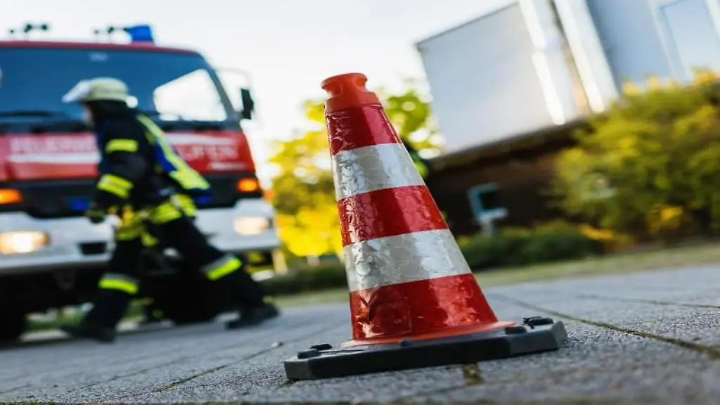 Ein-Feuerwehrmann-geht-an-einem-Einsatzfahrzeug-vorbei