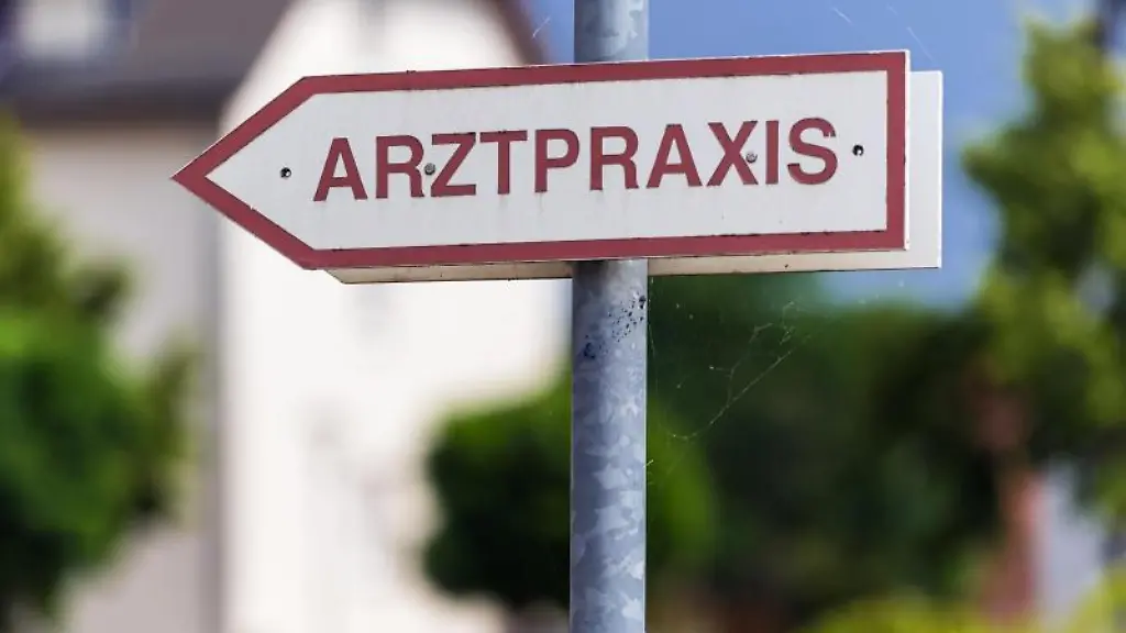 Ein-Schild-Arztpraxis-steht-an-der-Strasse