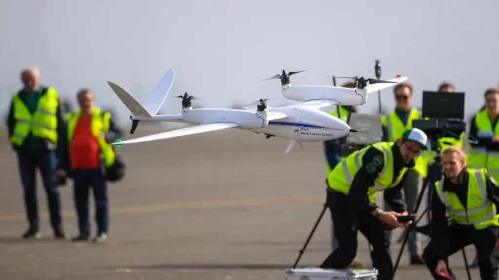 Eine-Drohne-landet-nach-dem-Testflug-vor-Mitarbeitern-des-Instituts-fuer-Optische-Sensorsysteme-des-Deutschen-Zentrum-fuer-Luft-und-Raumfahrt-DLR