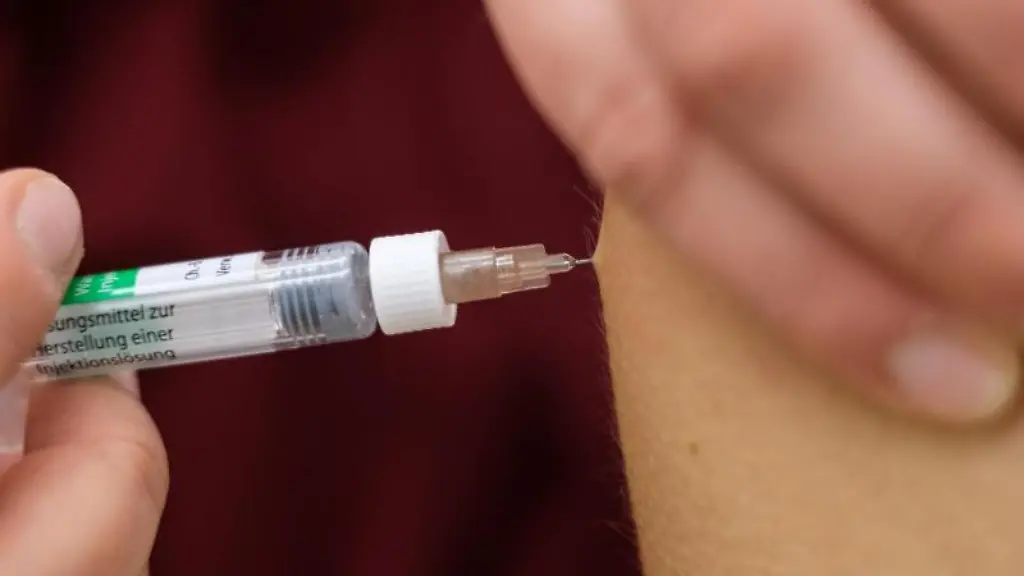 Eine-Arzthelferin-impft-eine-Patentin-mit-einer-Spritze