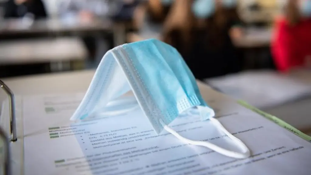Ein-Mund-Nasen-Schutz-liegt-im-Unterricht-auf-Unterlagen