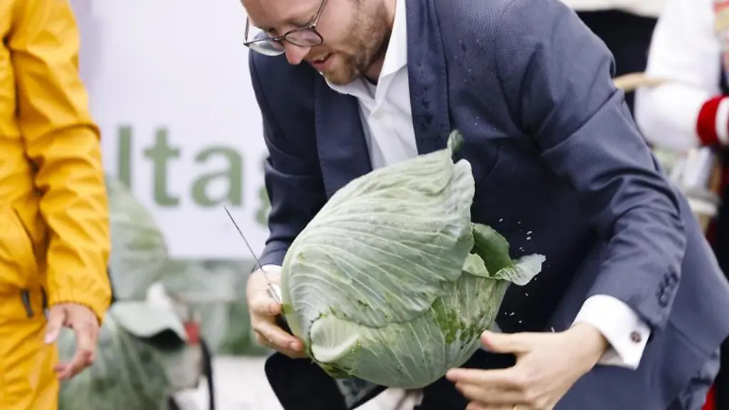 Agrarminister-Jan-Philipp-Albrecht-haelt-ein-Messer-und-einen-Kohlkopf-in-den-Haenden