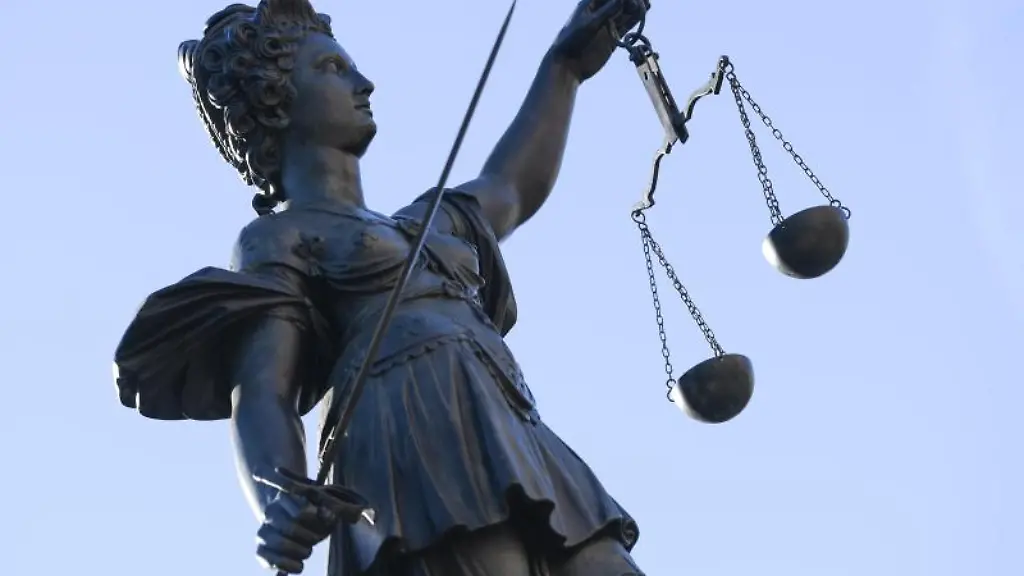 Eine-Statue-der-Justitia-steht-unter-freiem-Himmel
