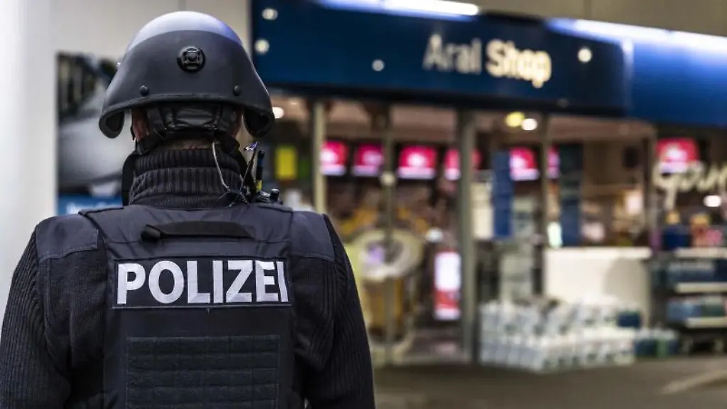 Ein-Polizist-sichert-am-fruehen-Morgen-eine-Tankstelle