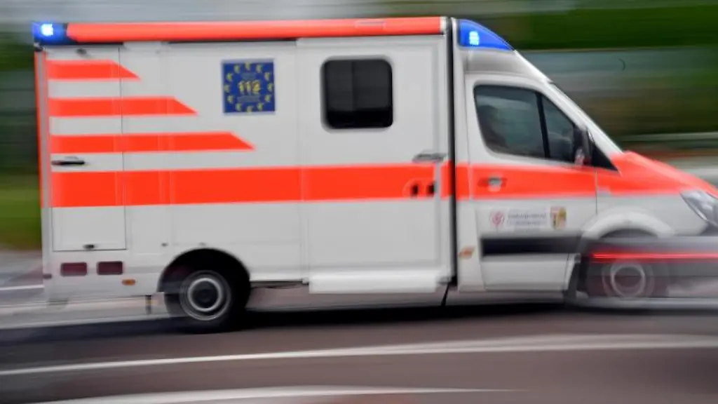 Ein-Krankenwagen-faehrt-mit-Blaulicht-auf-einer-Strasse