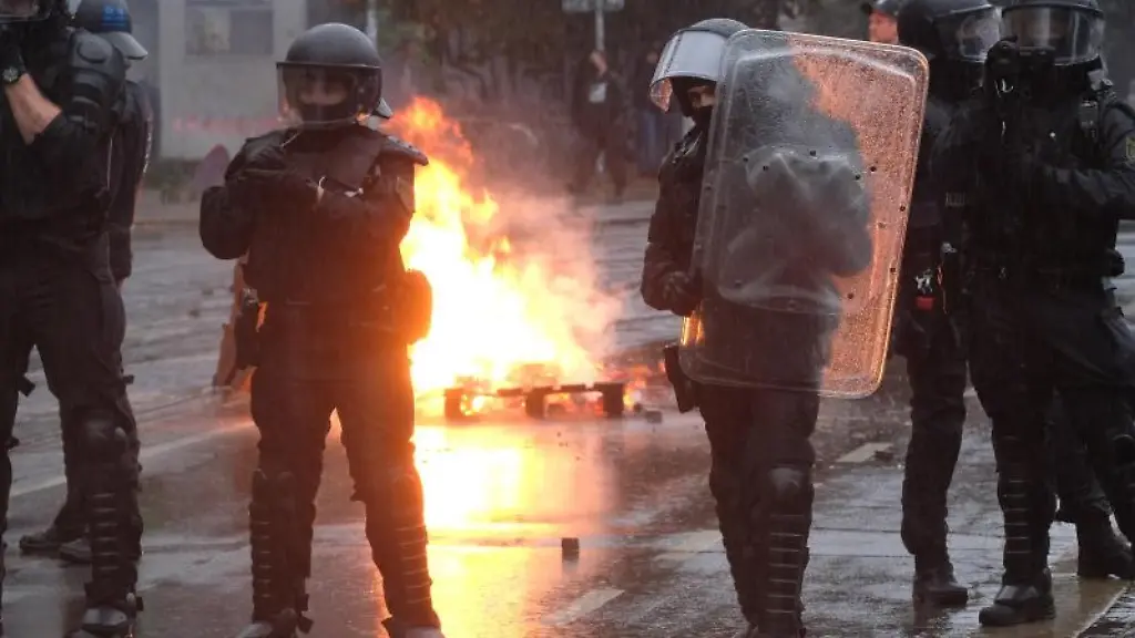 Polizisten-stehen-an-einer-brennenden-Barrikade-im-Stadtteil-Connewitz