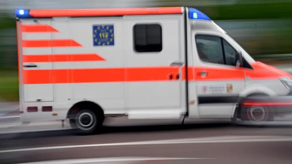 Ein-Krankenwagen-faehrt-mit-Blaulicht-auf-einer-Strasse