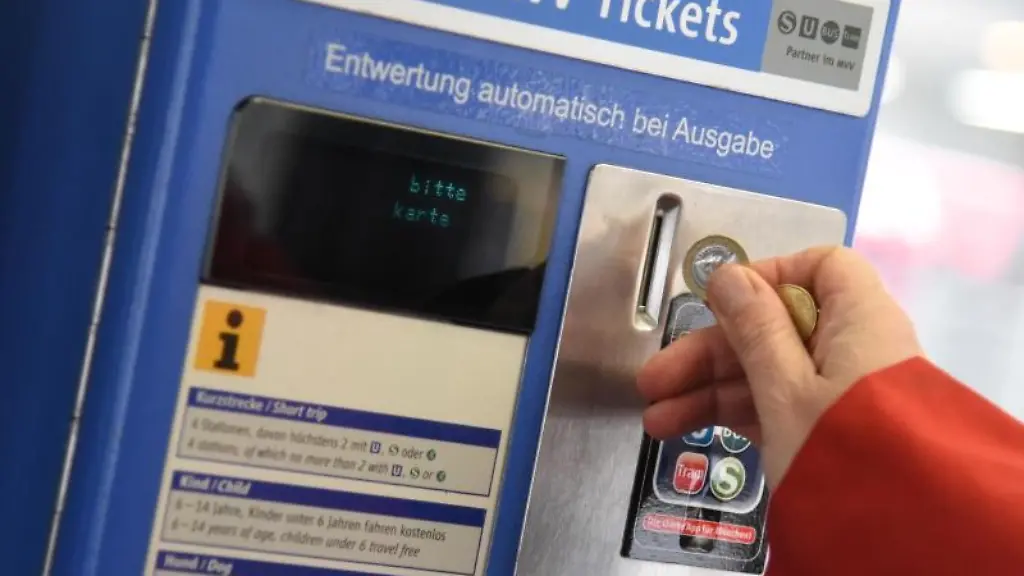 Eine-Frau-wirft-in-einer-Strassenbahn-in-Muenchen-eine-Muenze-ein