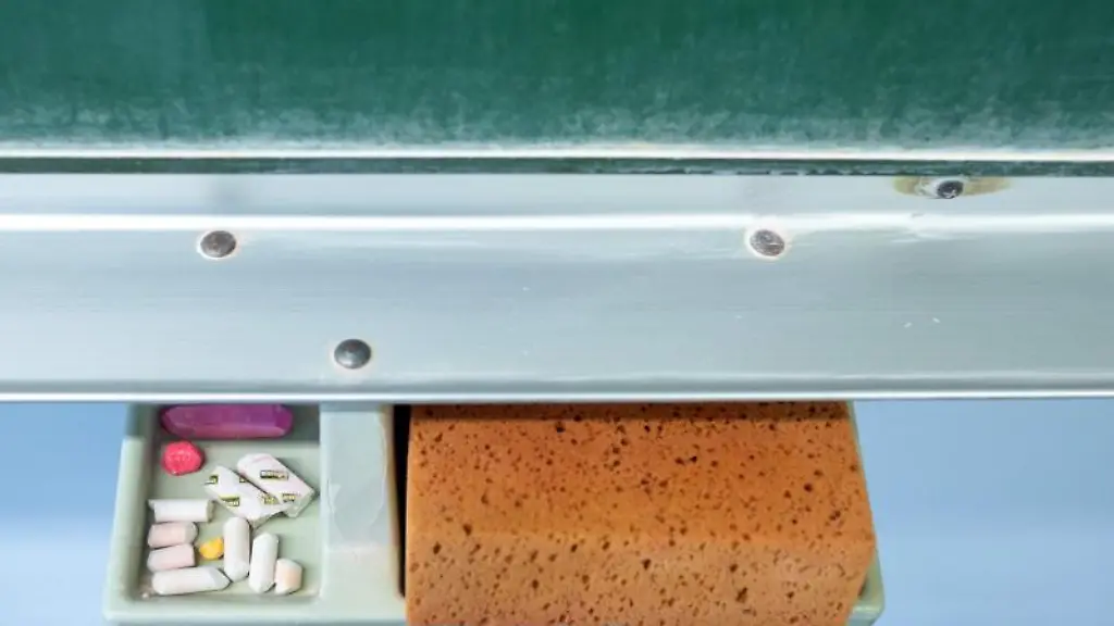 Schwamm-und-Kreide-liegen-in-einem-Klassenraum-unter-einer-Tafel