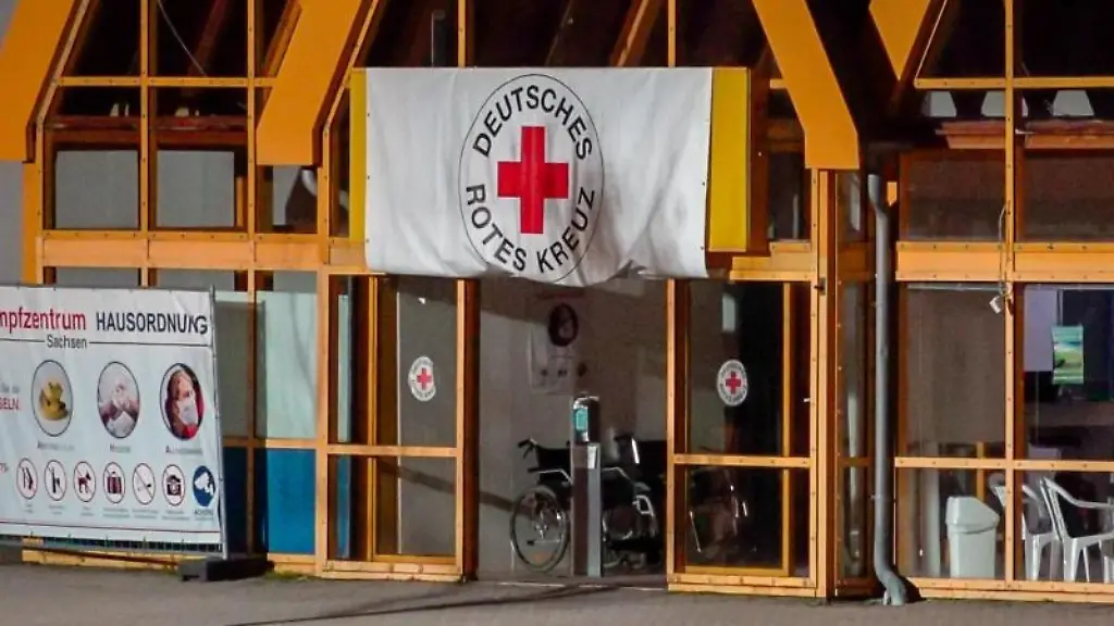 Eine-Rot-Kreuz-Fahne-haengt-ueber-dem-Eingang-zum-Impfzentrum