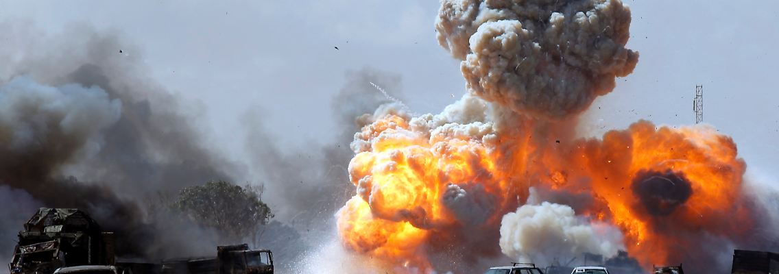 Ein Luftschlag trifft Wagen der Gaddafi-Anhänger.