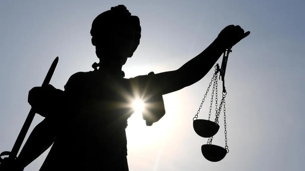 Eine-Statue-der-Justitia-mit-einer-Waage-und-einem-Schwert-in-ihren-Haenden