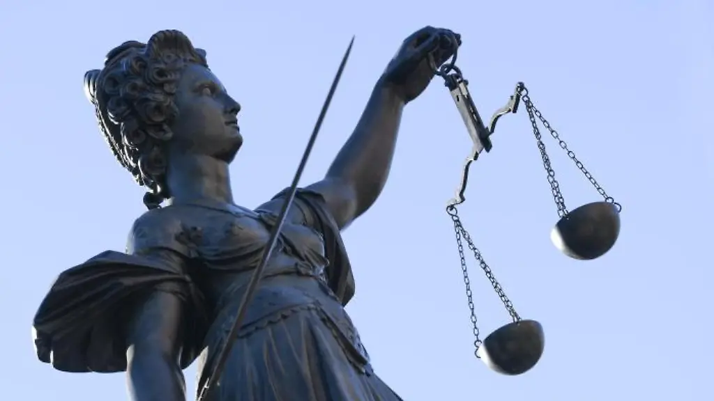 Eine-Statue-der-Justitia-steht-unter-freiem-Himmel