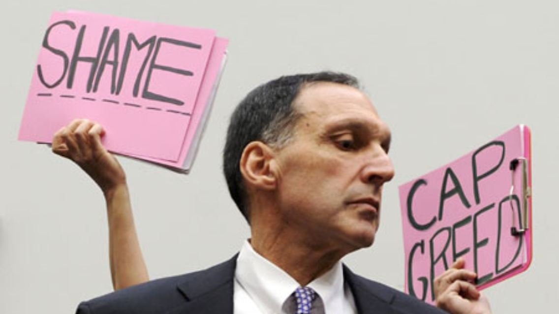 Hinter Richard Fuld, Chef von Lehman Brothers, recken Demonstranten wenig freundliche Botschaften in die Höhe.