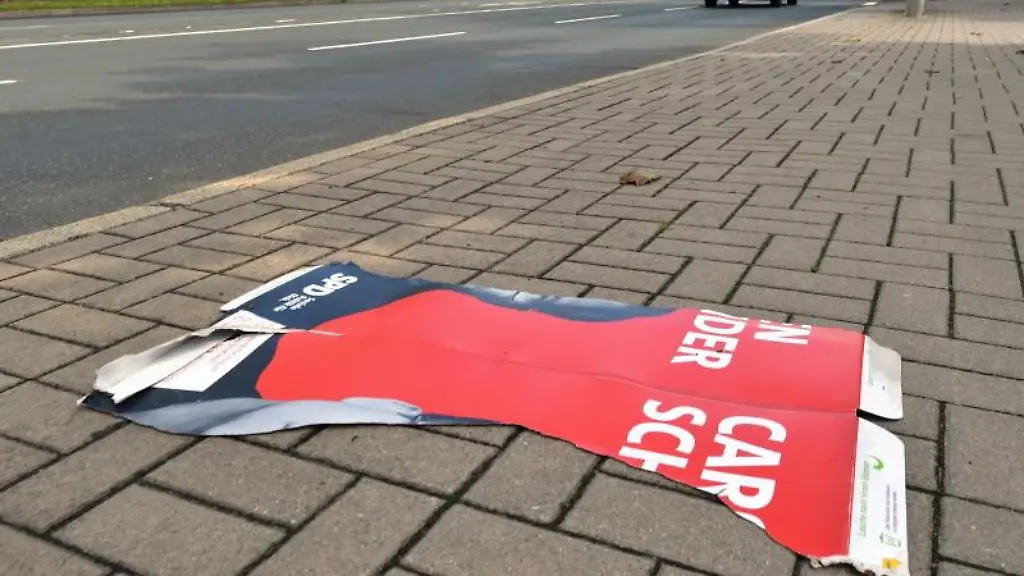 Der-abgerissene-Teil-eines-SPD-Wahlplakates-liegt-auf-dem-Fussweg