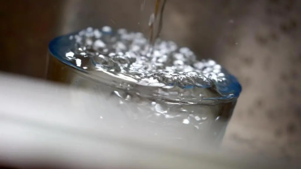 Leitungswasser-fliesst-in-ein-Glas-das-in-einem-Spuelbecken-steht