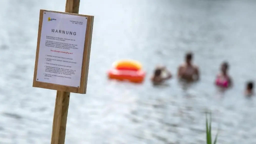 Ein-Schild-an-einem-Badesee-warnt-vor-Blaualgen