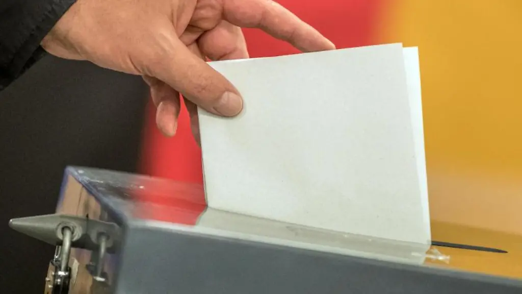 Ein-Waehler-wirft-seinen-Stimmzettel-in-eine-Wahlurne