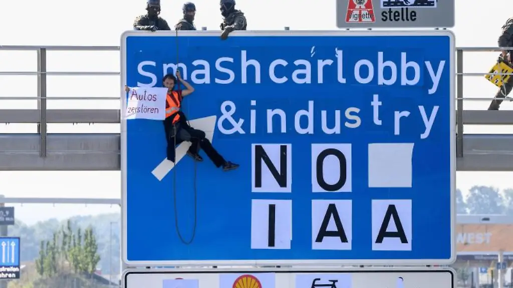 Ein-Aktivist-haengt-ueber-der-A9-an-einem-Schild