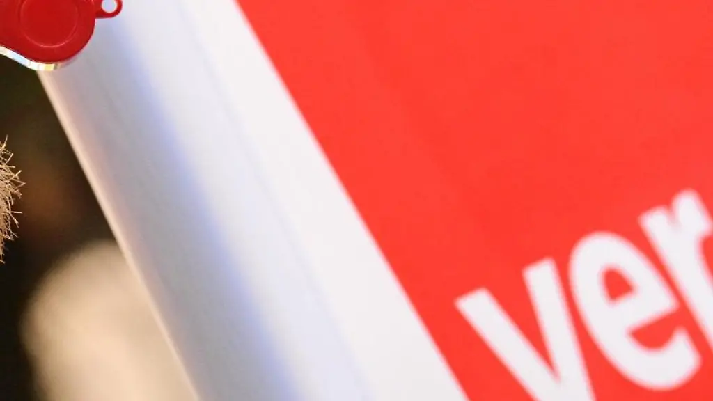 Ein-Mann-hat-bei-einem-Warnstreik-vor-dem-Verdi-Logo-eine-Pfeife-im-Mund