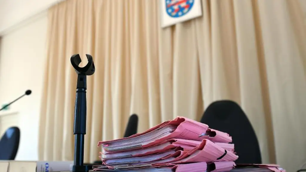 Akten-liegen-zum-Prozessauftakt-im-Landgericht-auf-einem-Tisch