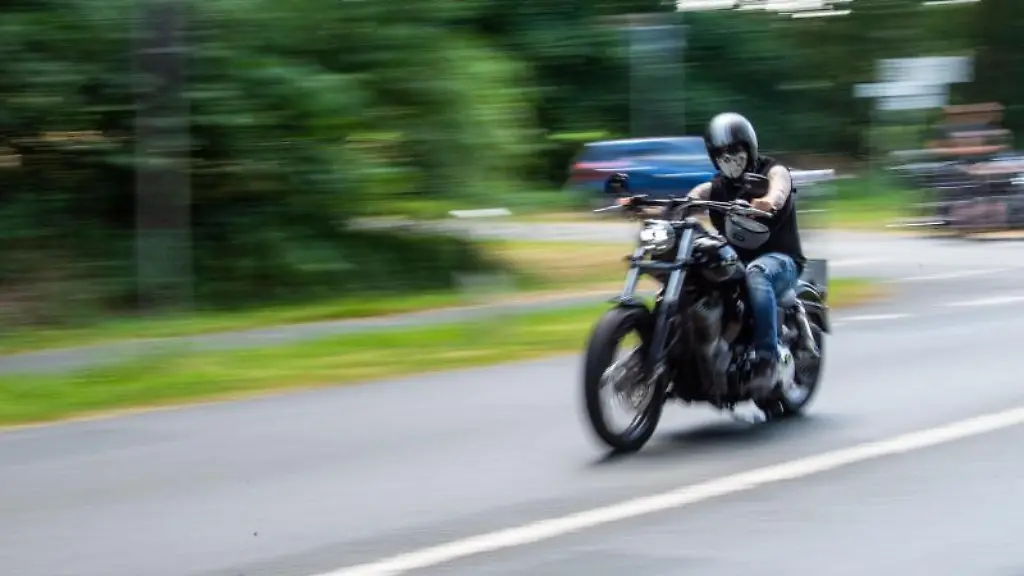 Ein-Motorradfahrer-faehrt-ueber-eine-Landstrasse