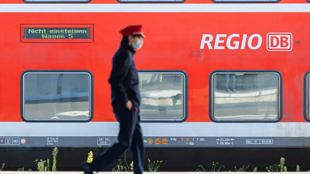 Ein-Mitarbeiter-der-Deutschen-Bahn-geht-ueber-einen-Bahnsteig