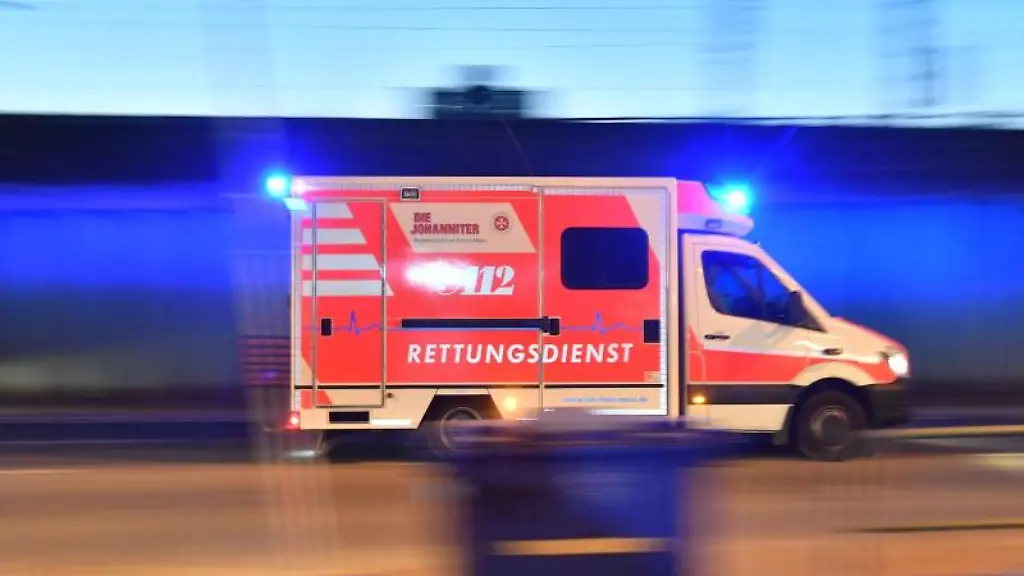 Ein-Rettungswagen-mit-eingeschaltetem-Blaulicht-faehrt-auf-einer-Strasse