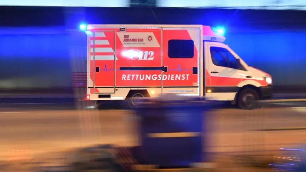 Ein-Rettungswagen-mit-eingeschaltetem-Blaulicht-faehrt-auf-einer-Strasse