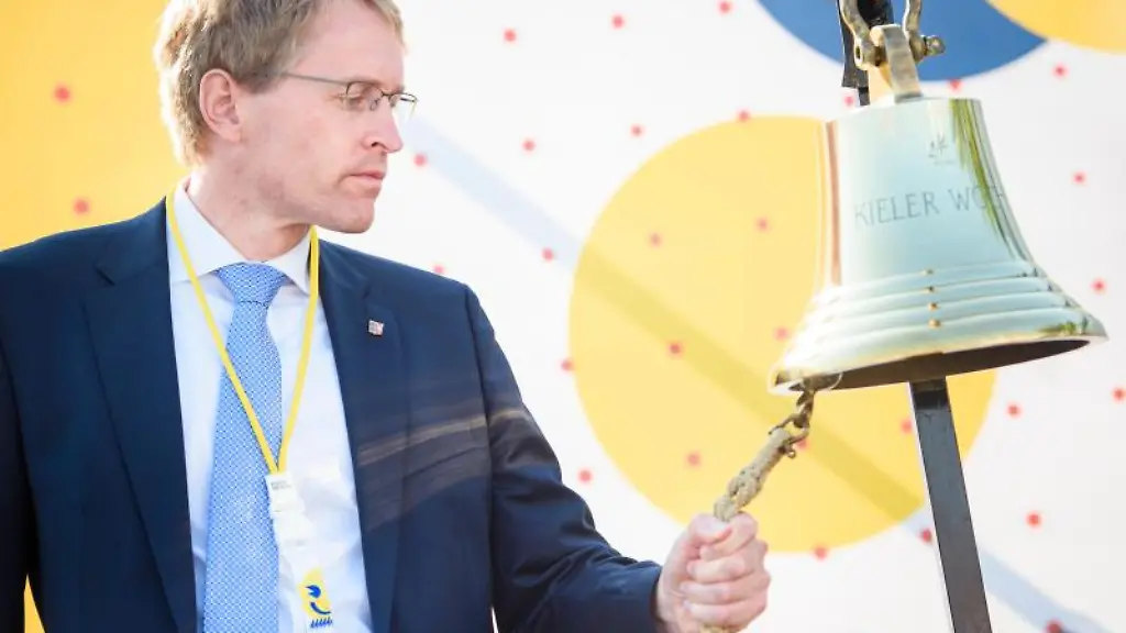 Daniel-Guenther-CDU-laeutet-Glasen-zur-offiziellen-Eroeffnung-der-Kieler-Woche-auf-einer-Buehne-im-Olympiastuetzpunkt-Schilksee-eine-Schiffsglocke