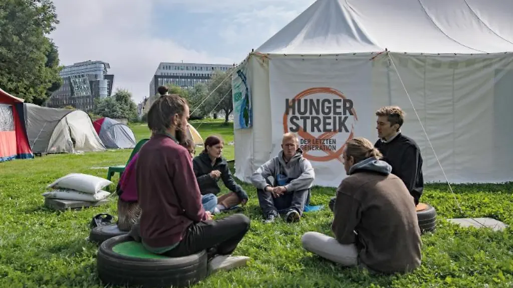 Umweltaktivisten-sitzen-im-Regierungsviertel-zusammen-vor-einem-Zelt