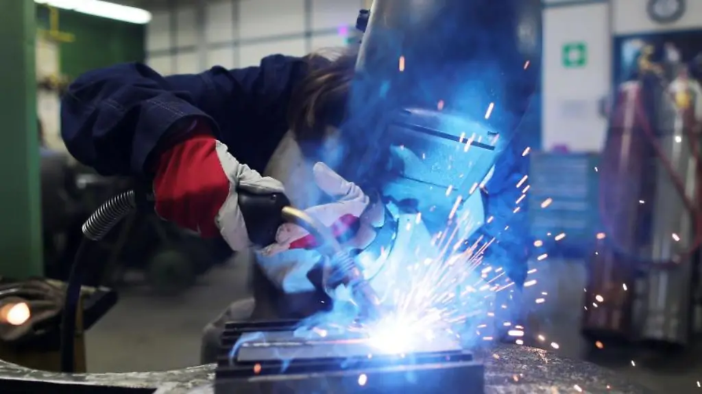Eine-Auszubildende-zur-Schweisserin-arbeitet-in-einem-Ausbildungszentrum-an-einem-Stueck-Metall
