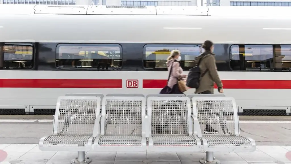 Zwei-Frauen-gehen-an-einem-Bahnhof-an-einem-ICE-vorbei