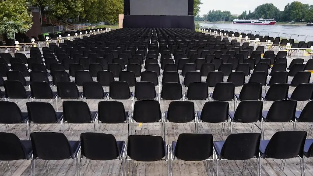 Stuehle-stehen-auf-dem-Veranstaltungsgelaende-fuer-das-Festival-des-deutschen-Films-vor-einer-Leinwand