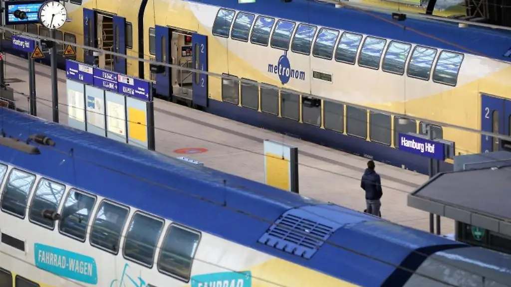 Ein-Reisender-steht-zwischen-zwei-Metronom-Zuegen