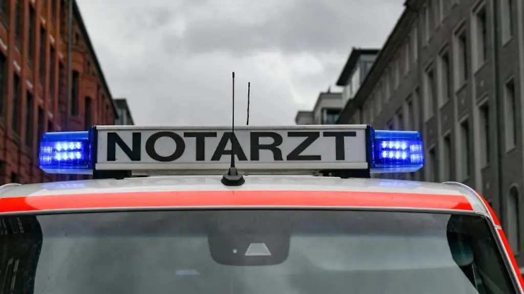Ein-Notarztwagen-steht-mit-eingeschaltetem-Blaulicht-auf-der-Strasse
