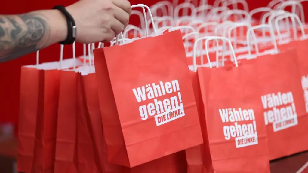 Ein-Mann-greift-beim-Start-der-Linken-Wahlkampfveranstaltungen-nach-einer-Papiertuete-mit-Wahlwerbung