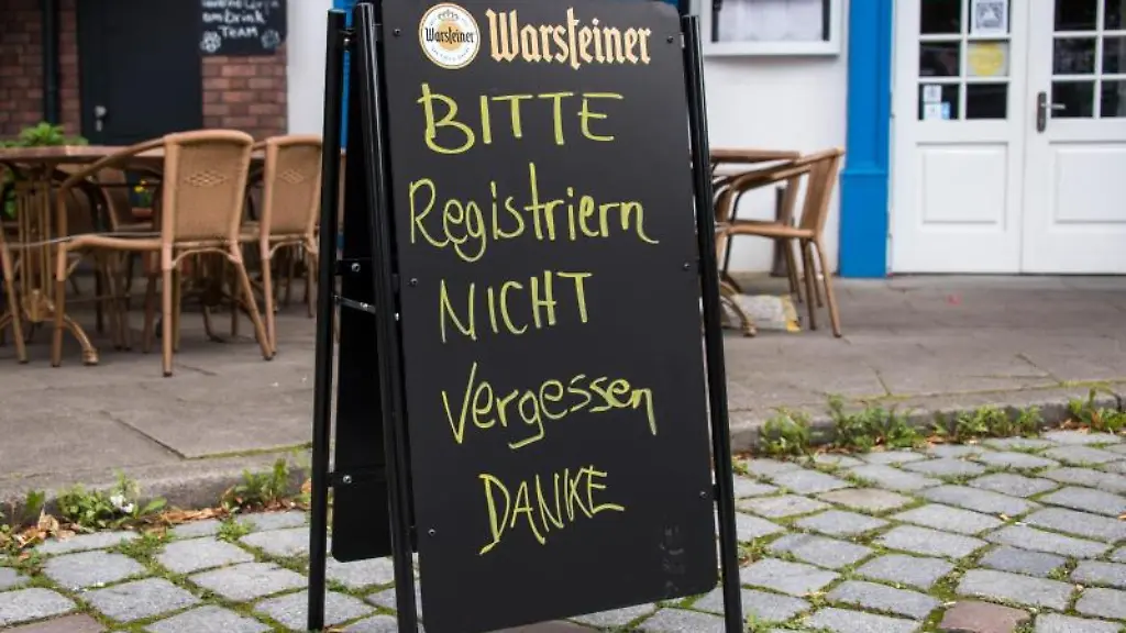 Eine-Tafel-mit-der-Aufschrift-Bitte-Registrieren-nicht-vergessen-Danke-steht-vor-einem-Restaurant