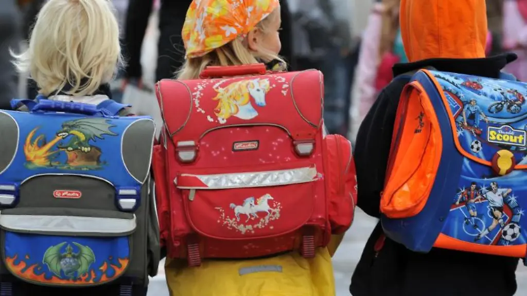 Drei-Kinder-laufen-mit-ihren-Schulranzen-zur-Schule