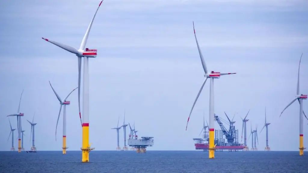 Ein-Arbeitsschiff-steht-auf-Stelzen-zwischen-den-Windraedern-die-in-der-Ostsee-errichtet-wurden