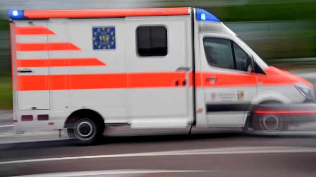 Ein-Krankenwagen-faehrt-mit-Blaulicht-auf-einer-Strasse