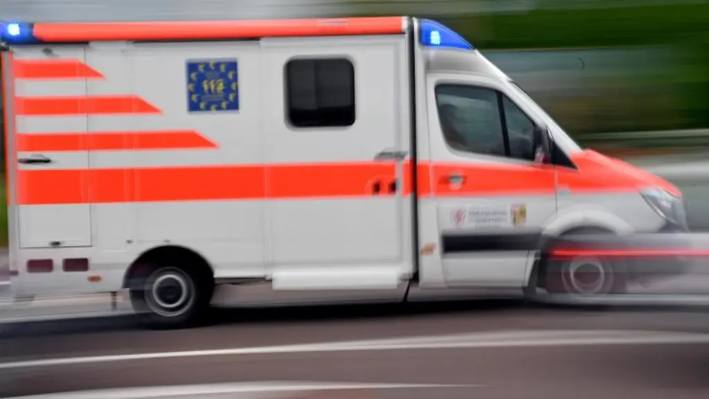 Ein-Krankenwagen-faehrt-mit-Blaulicht-auf-einer-Strasse