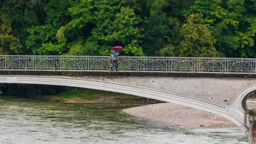 Ein-Paerchen-geht-bei-Regen-mit-einem-Schirm-ueber-die-Kabelsteg-Bruecke