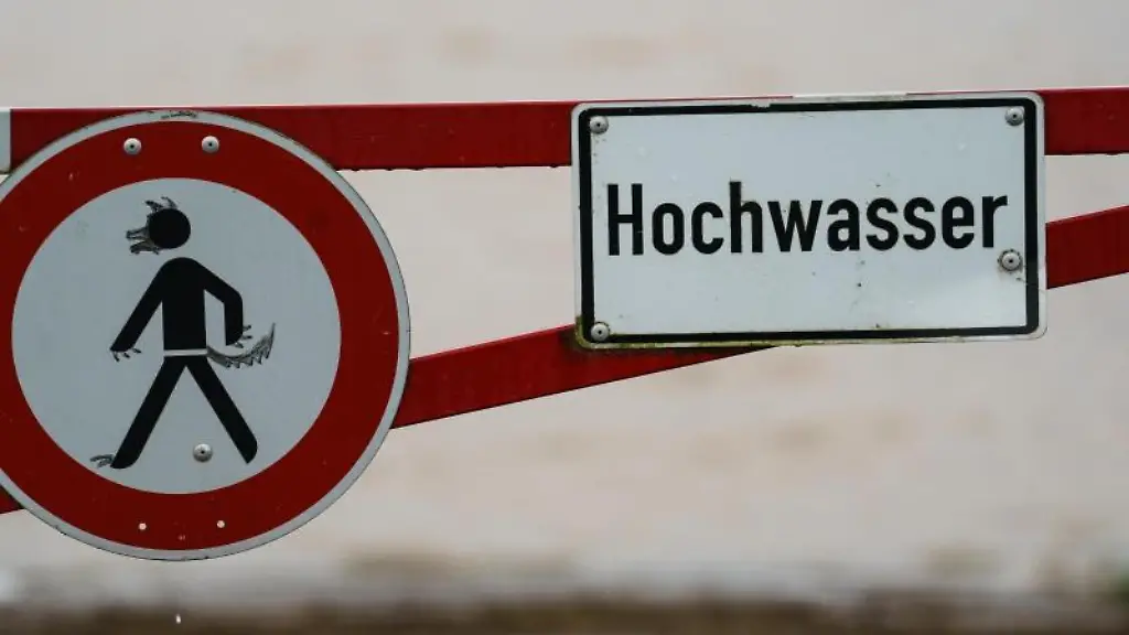 Ein-Hochwasser-Schild-steht-an-einem-ueberfluteten-Feld