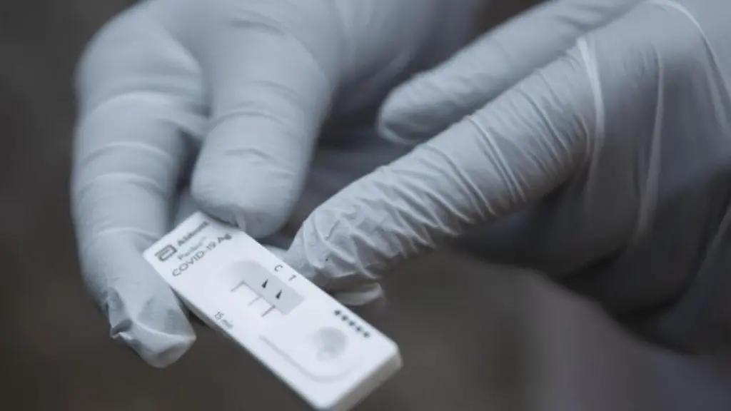 Ein-Mitarbeiter-des-Roten-Kreuzes-haelt-einen-Corona-Schnelltest-in-der-Hand