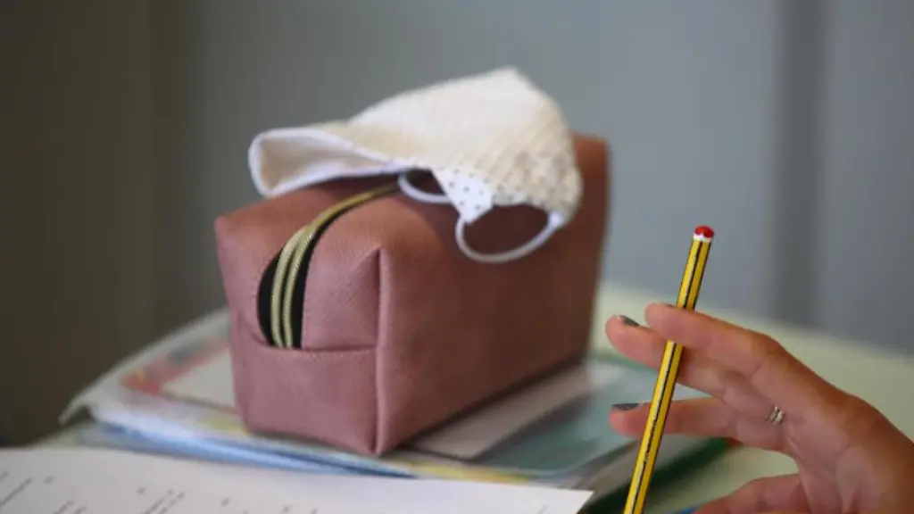 Schulutensilien-und-eine-Gesichtsmaske-liegen-auf-einem-Tisch-im-Gymnasium-Gleichense