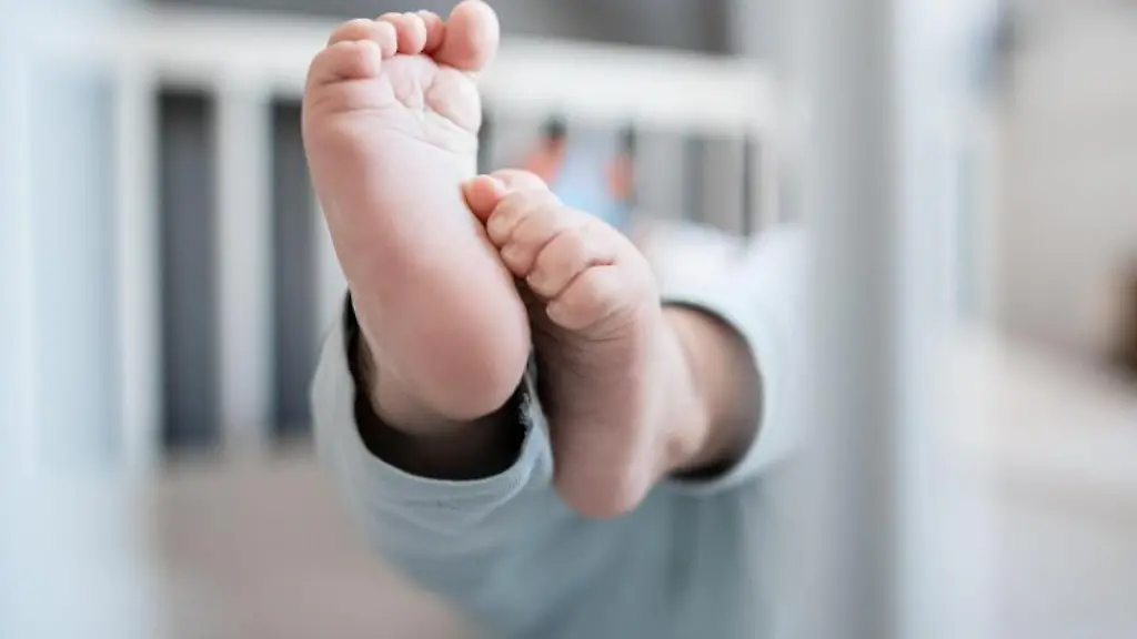 Die-Fuesse-eines-Babys-sind-in-einem-Kinderbett-zu-sehen