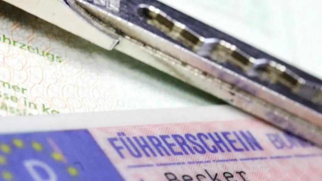 Ein-Fuehrerschein-und-ein-Autoschluessel-auf-einem-Fahrzeugschein