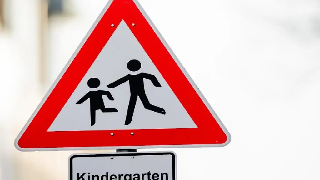 Ein-Verkehrsschild-mit-dem-Hinweis-Kindergarten-steht-vor-einer-Kindertagesstaette